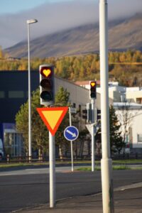 Heart-shaped traffic light in Akureyri, Iceland, showing a unique design amidst urban landscape.